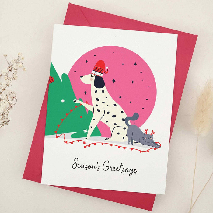 Festive Christmas card Season’s Greetings with Dalmatian dog and cat illustration, styled on red envelope – XOXOKristen