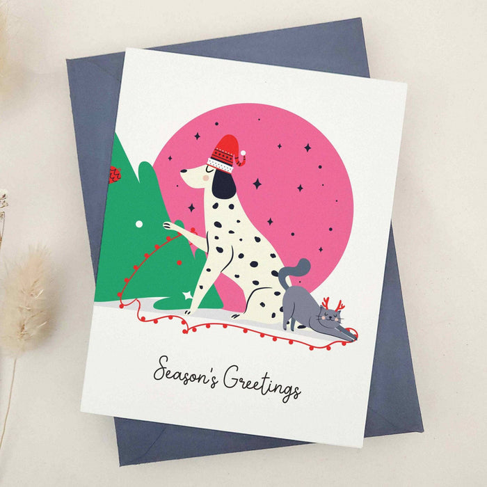 Modern Season’s Greetings holiday card featuring dog and cat design, placed on navy envelope – XOXOKristen