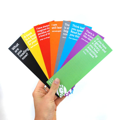 A collection of colorful paper bookmarks with quotes printed on them, fanned out.